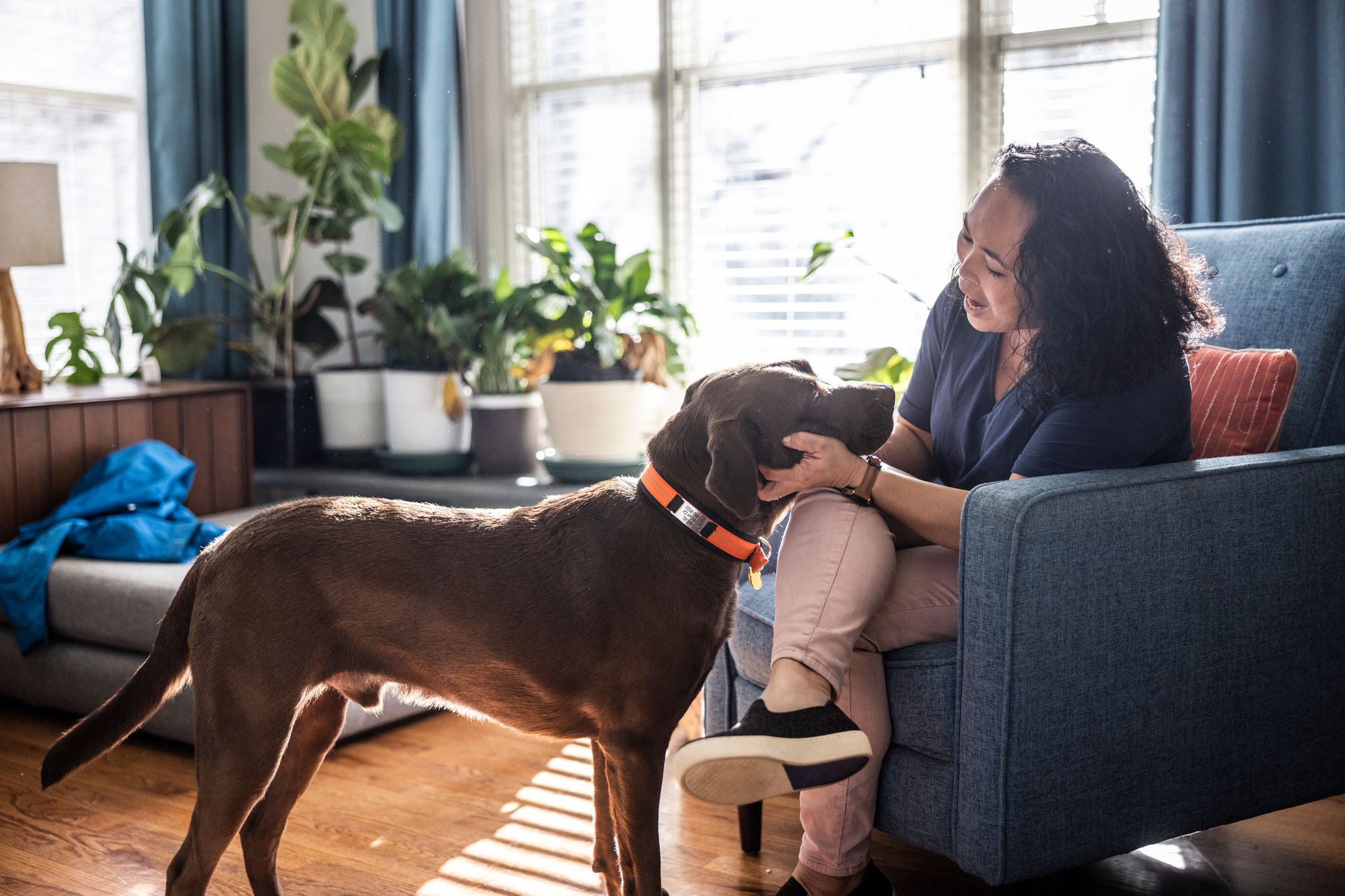 Woman playing with her dog in living room