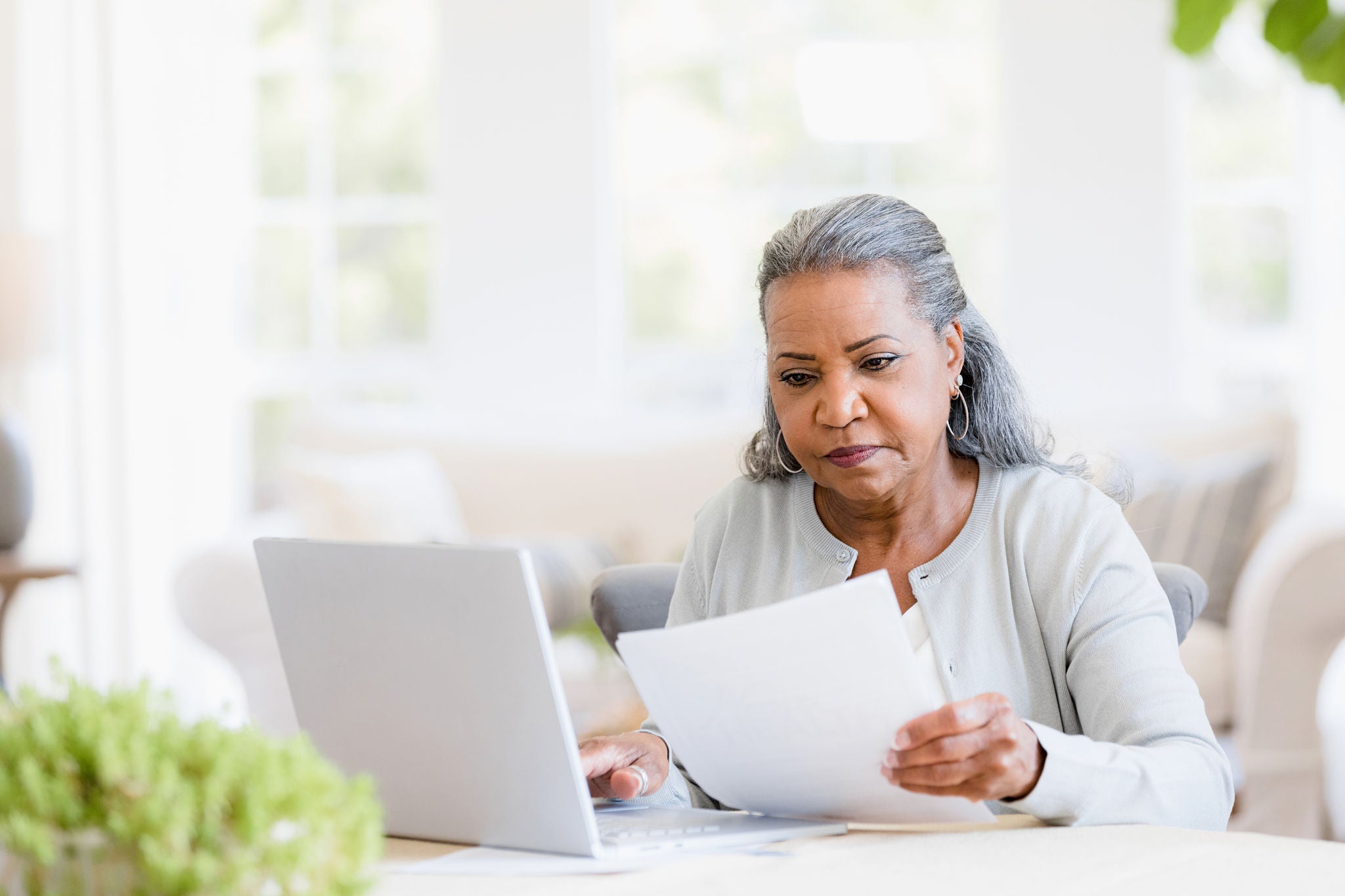 The serious senior adult widow is worried about her home finances.