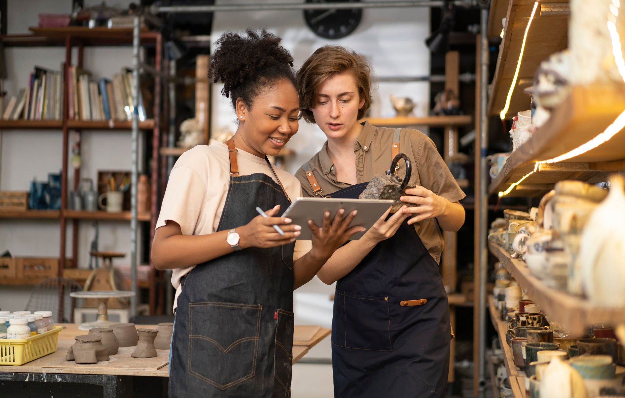 Female worker check stock ceramic products on shelf pottery shop