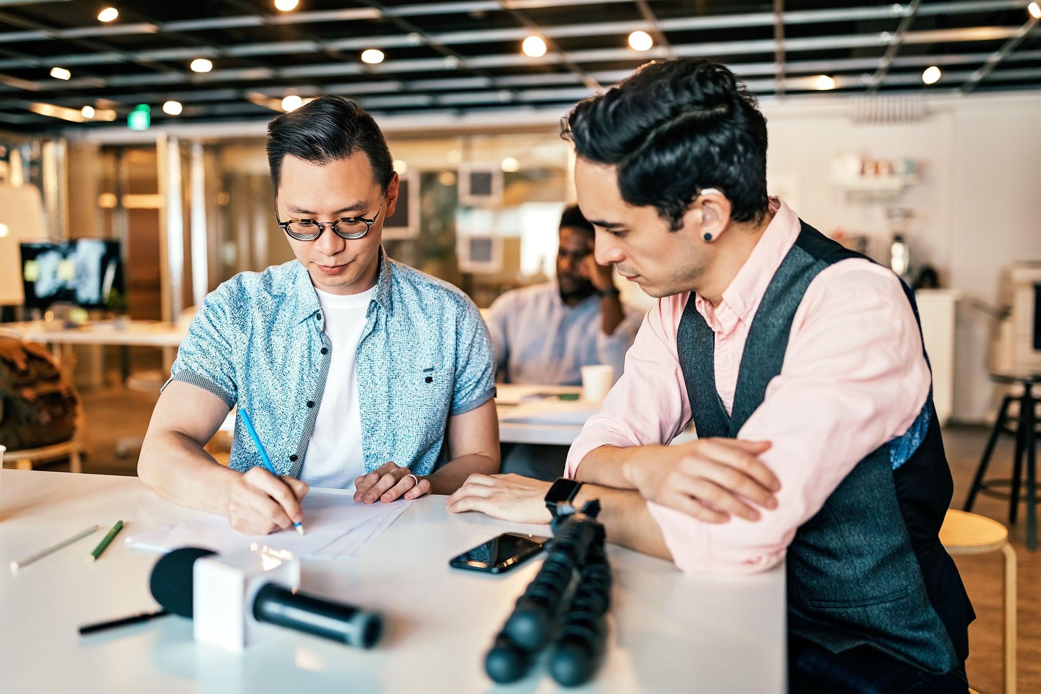 Young Businessman Working With Colleagues In Office In Spite Of His Hearing Disability