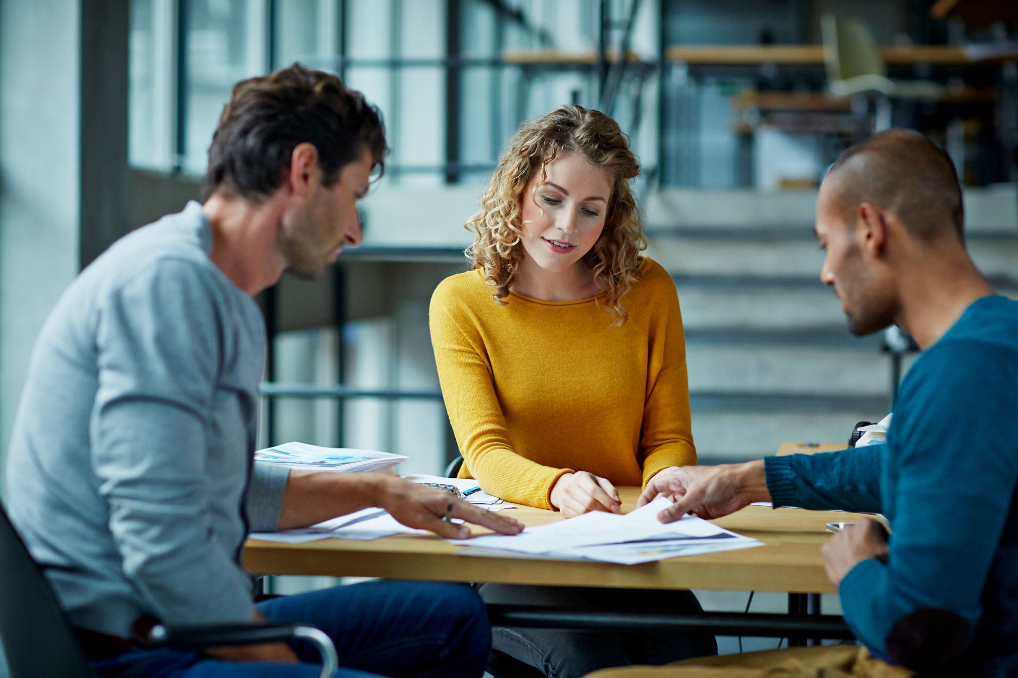 Coworkers working on project at table in modern studio