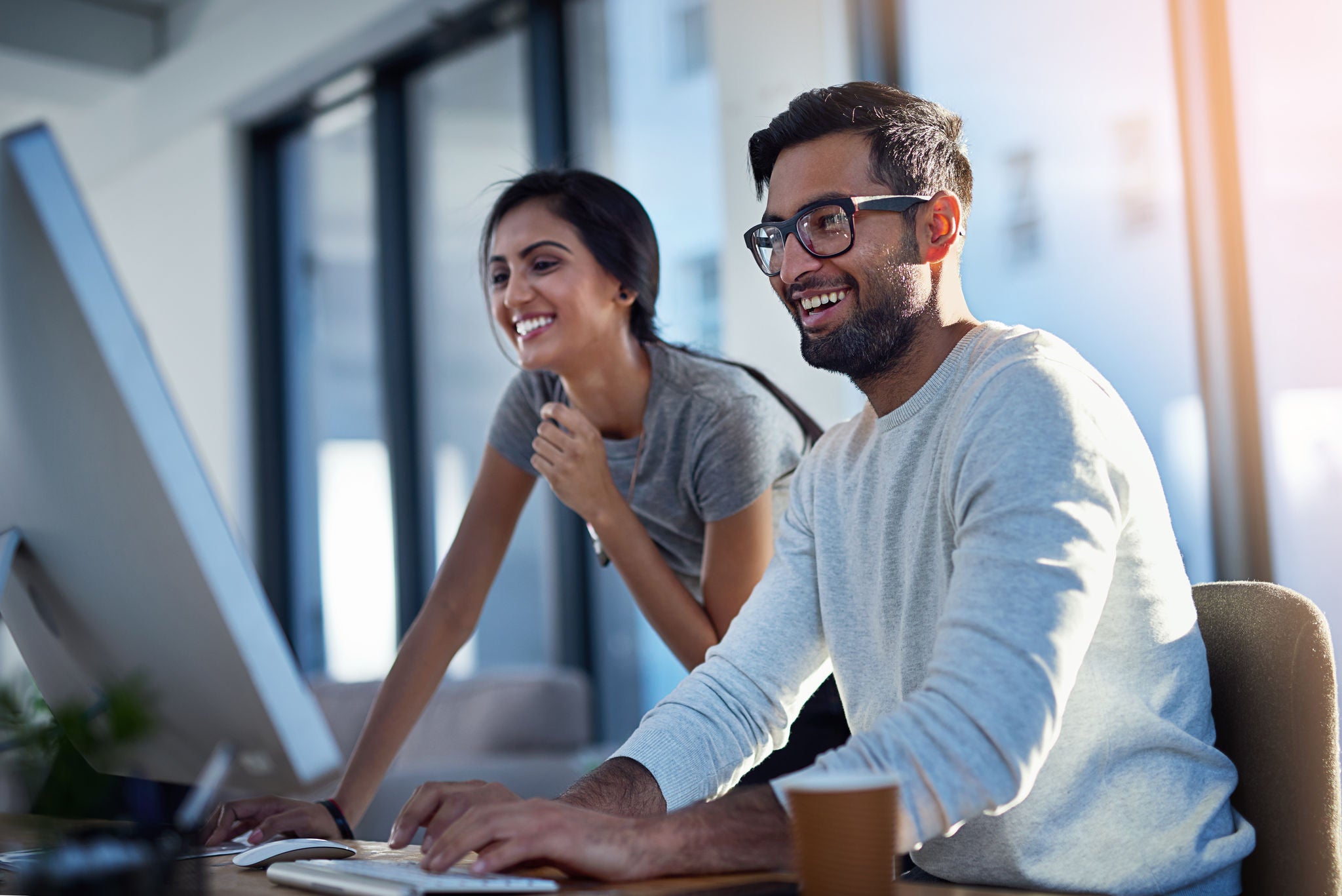 Shot of two young coworkers using a computer together at work