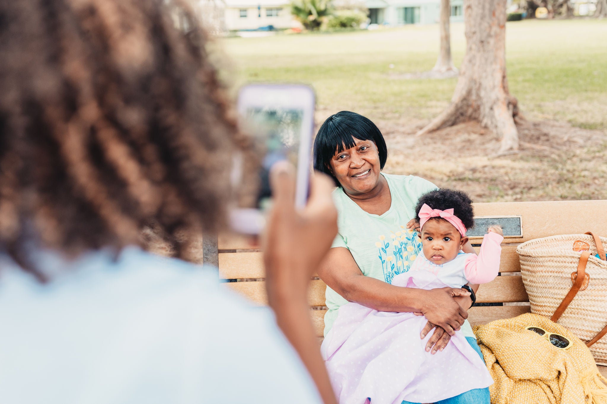 Woman and child on a park bench while their photo is being taken